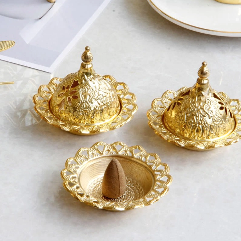 Gold handcrafted Buddhist incense burner set with carved patterns, displayed overhead on marble surface with cone incense