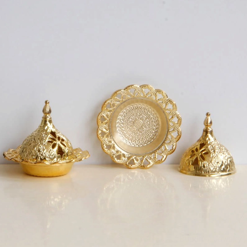 Gold incense burner kit with two lidded burners and two empty lace-edged trays on marble tabletop