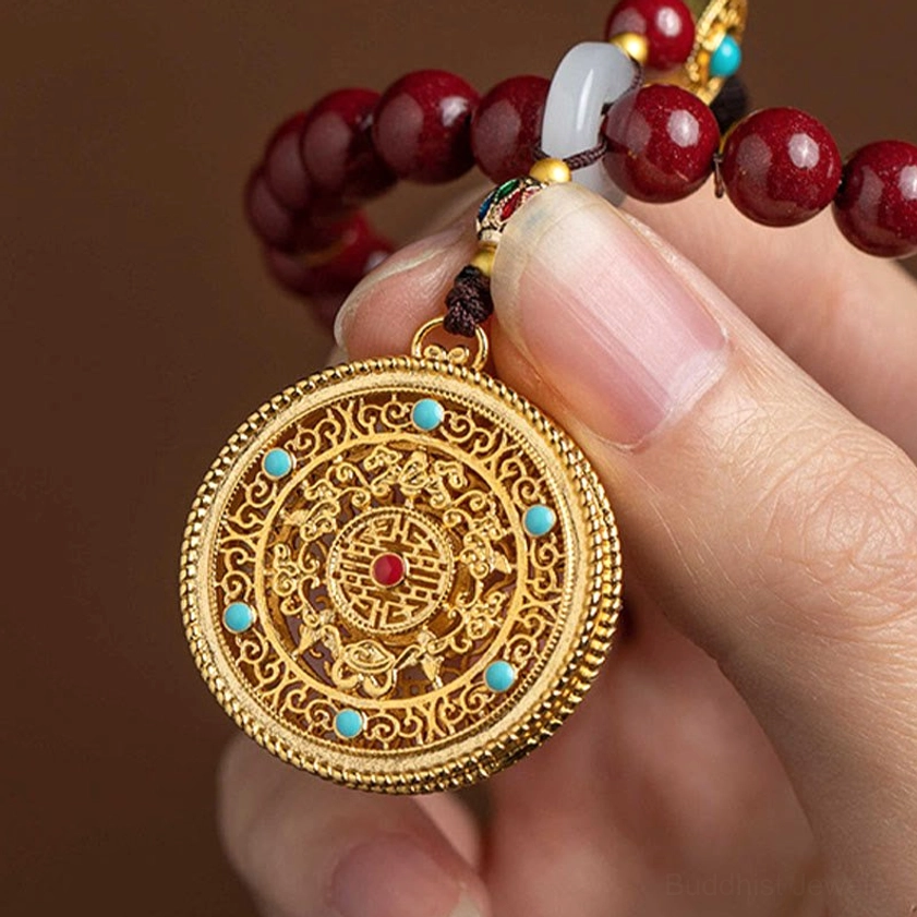 Close-up of ornate gold filigree round pendant with turquoise inlay, traditional Buddhist ruyi car hanging ornament centerpiece