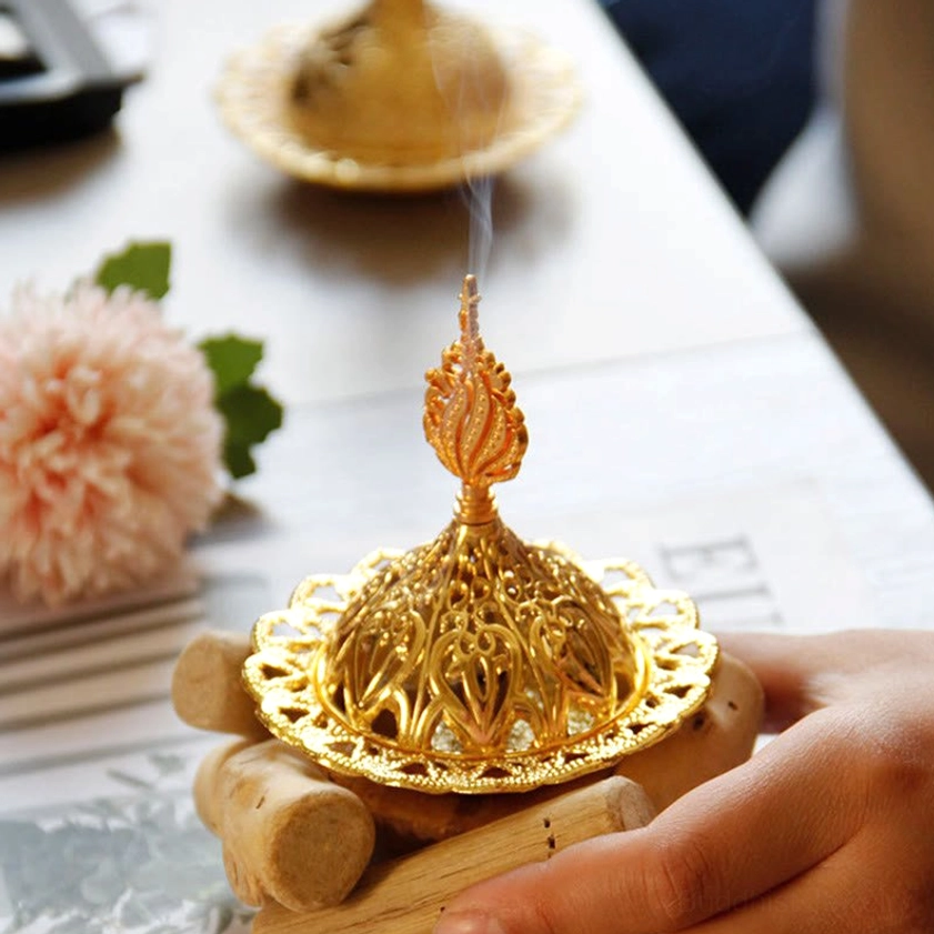 Gold incense burner set in meditation room ambiance with candles and spiritual decor - lifestyle setting