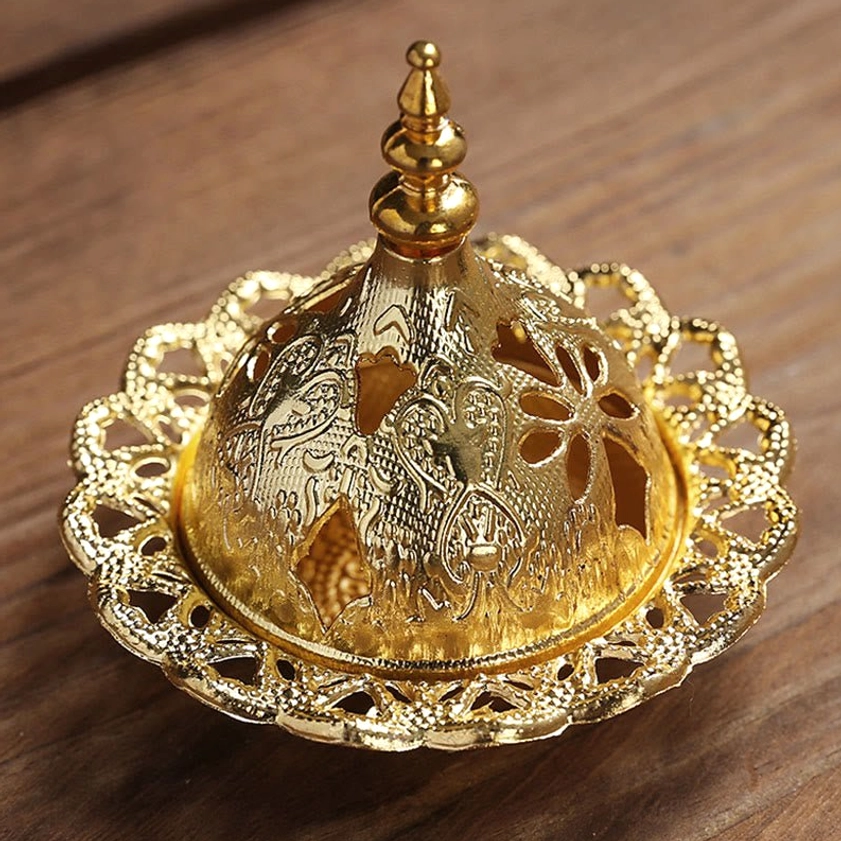 Overhead view of gold incense burner showing intricate mandala carving and scalloped edge design
