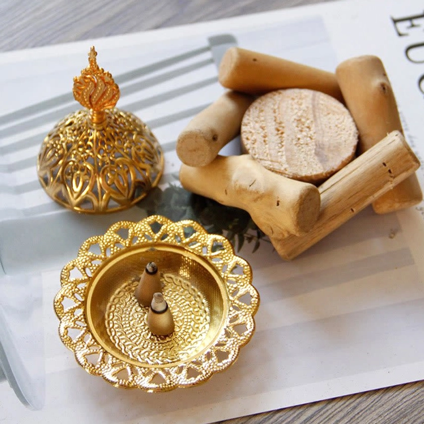 Gold carved incense burner tray with two incense cones, separate metal lid and natural wooden base - side oblique angle