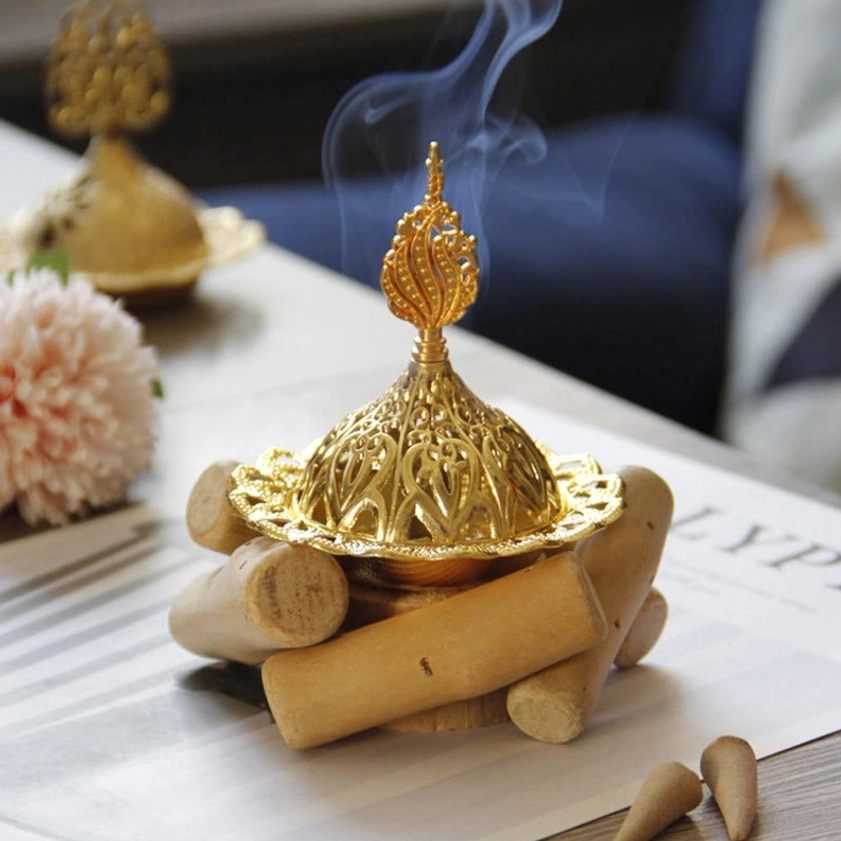 Gold incense holder detail showing intricate hollow carved patterns and metal craftsmanship - macro close-up