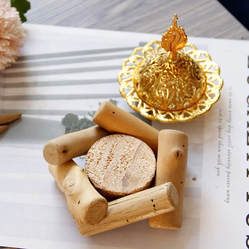 Complete gold incense holder and wooden coaster set flat lay on dining table - overhead view showing ornate carved design