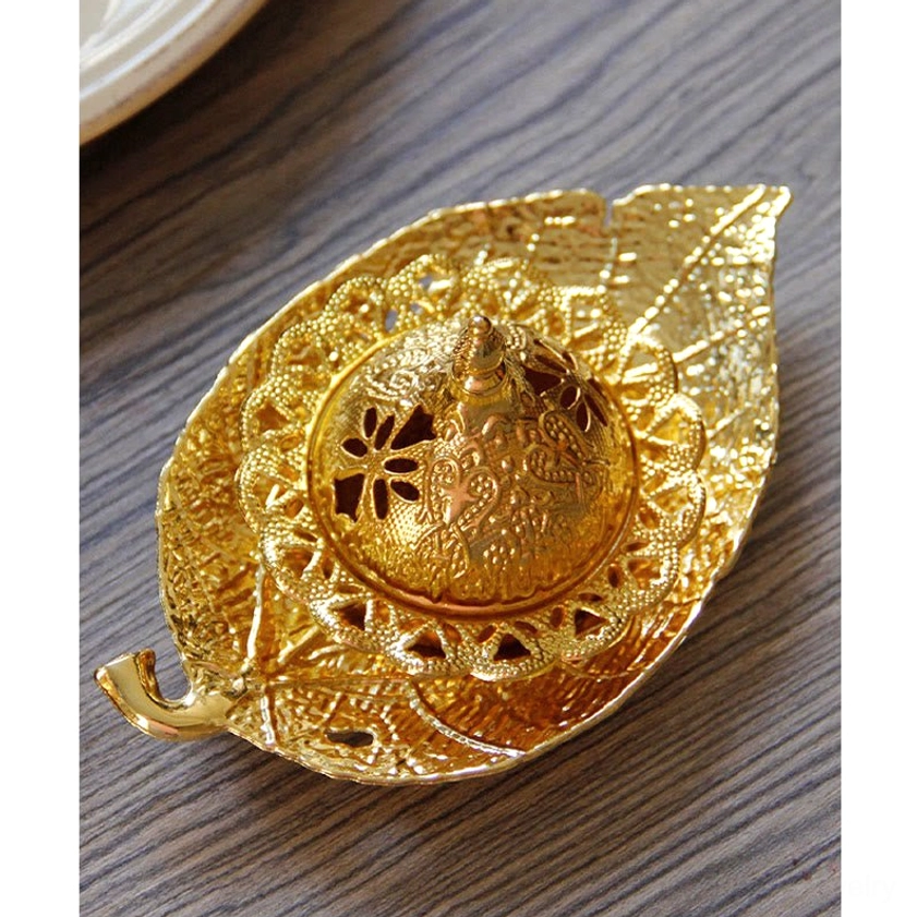 Close-up overhead of gold leaf incense burner showing intricate floral carvings and glossy golden finish