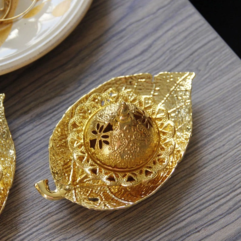 Gold leaf incense burner overhead flat lay showing embossed leaf pattern and fully assembled design