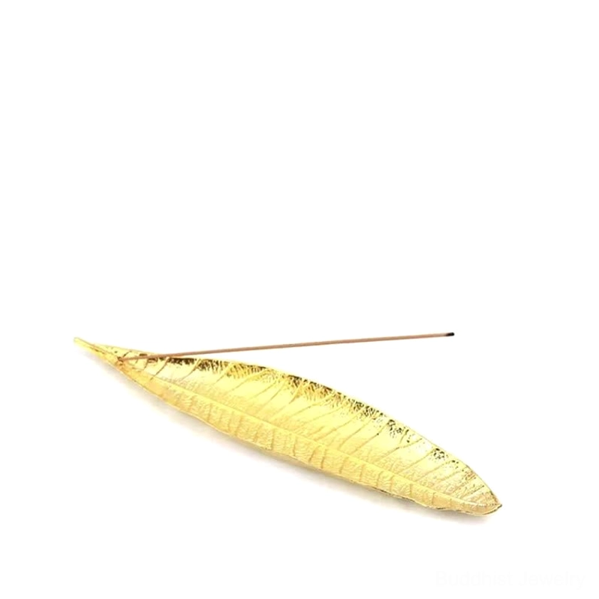 Gold alloy leaf-shaped incense holder on white background flat lay top view