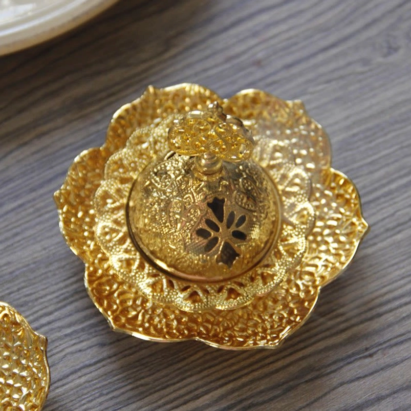 Gold incense holder on lotus tray with closed carved lid and layered floral design, top-down front view