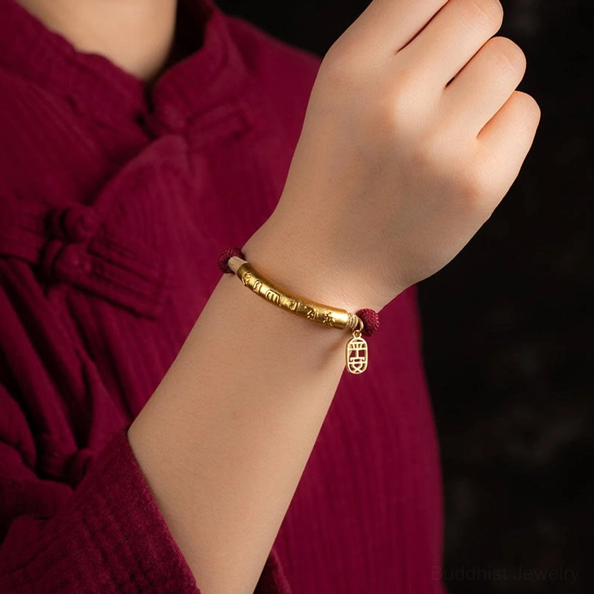 Wearing gold-tone Om Mani Padme Hum bracelet on wrist traditional Buddhist jewelry