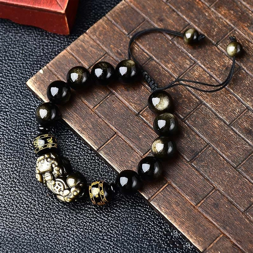 Gold sheen obsidian Pixiu bracelet, 12mm bead size, featuring prominent charm and Om Mani Padme Hum spacer beads on red wooden background