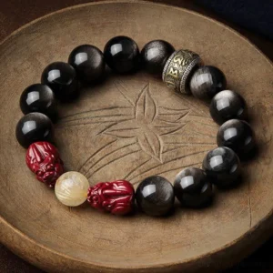 Gold sheen obsidian pixiu cinnabar Buddhist protection bracelet with om mani padme hum mantra spacer on wooden tray