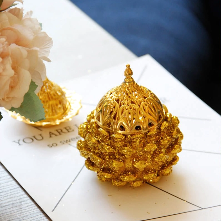 Gold pine cone incense burner displayed in bedroom creating peaceful relaxation atmosphere