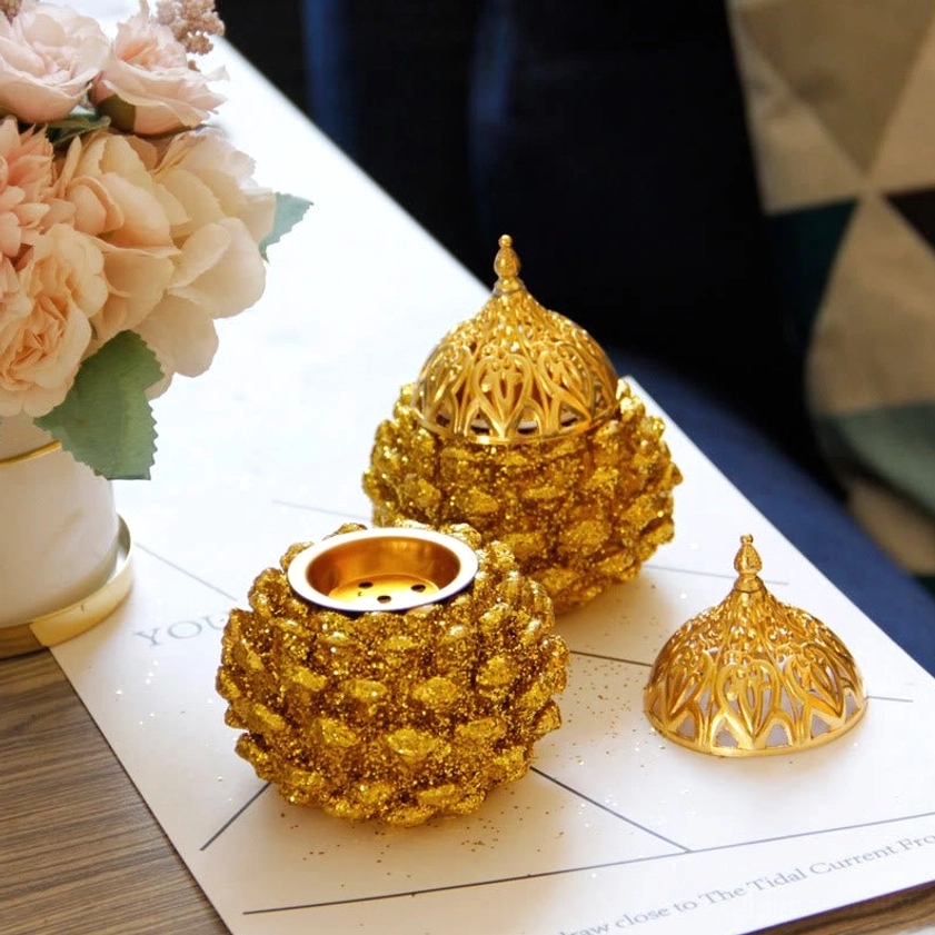 Pair of matching gold pine cone incense burners with coordinated hollow lids displayed together
