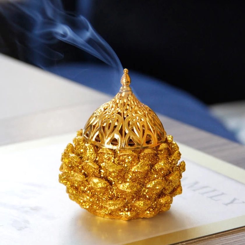 Gold pine cone incense burner in yoga studio setting for enhancing wellness and spiritual practice