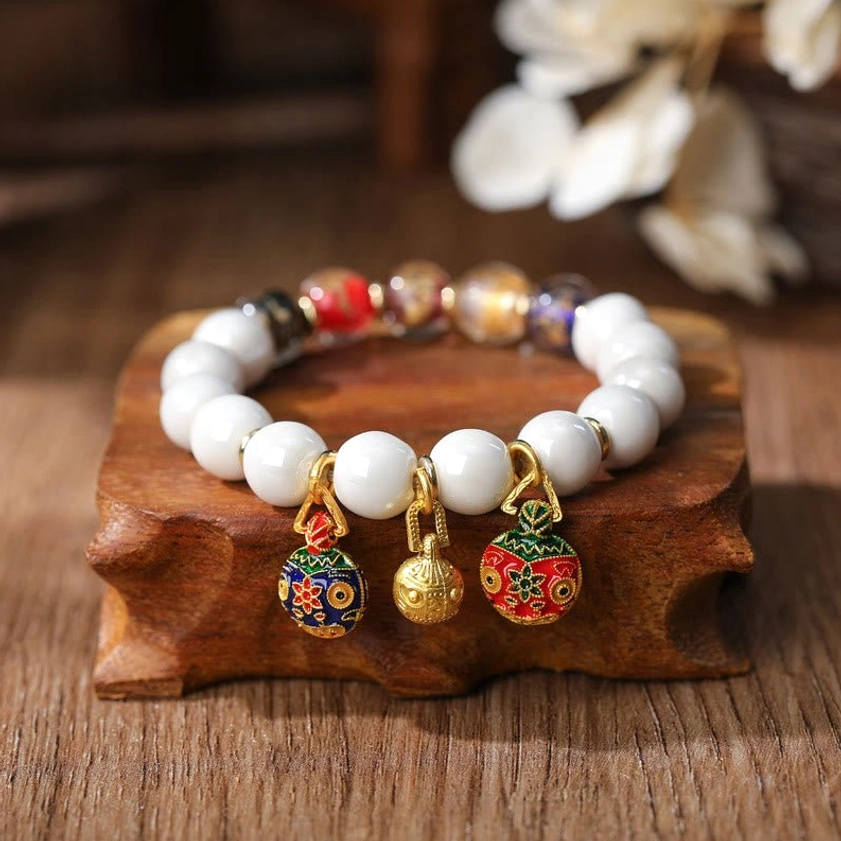 Gold Pixiu family bracelet with multicolored gold and silver foil beads and enamel charm details