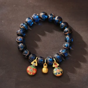 Gold Pixiu wealth bracelet with blue liuli glass beads and three protective prosperity charms - overhead view