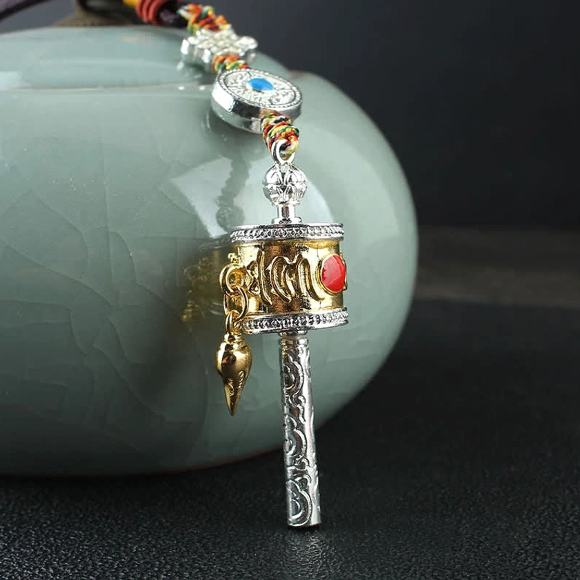 Mini Buddhist prayer wheel hanging decor with gold-silver tone, red inlaid stone, engraved sutra, and pointed golden pendant