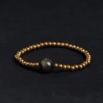 Gold Sheen Obsidian Copper Brass Buddhist bracelet top view flat lay with large obsidian center stone