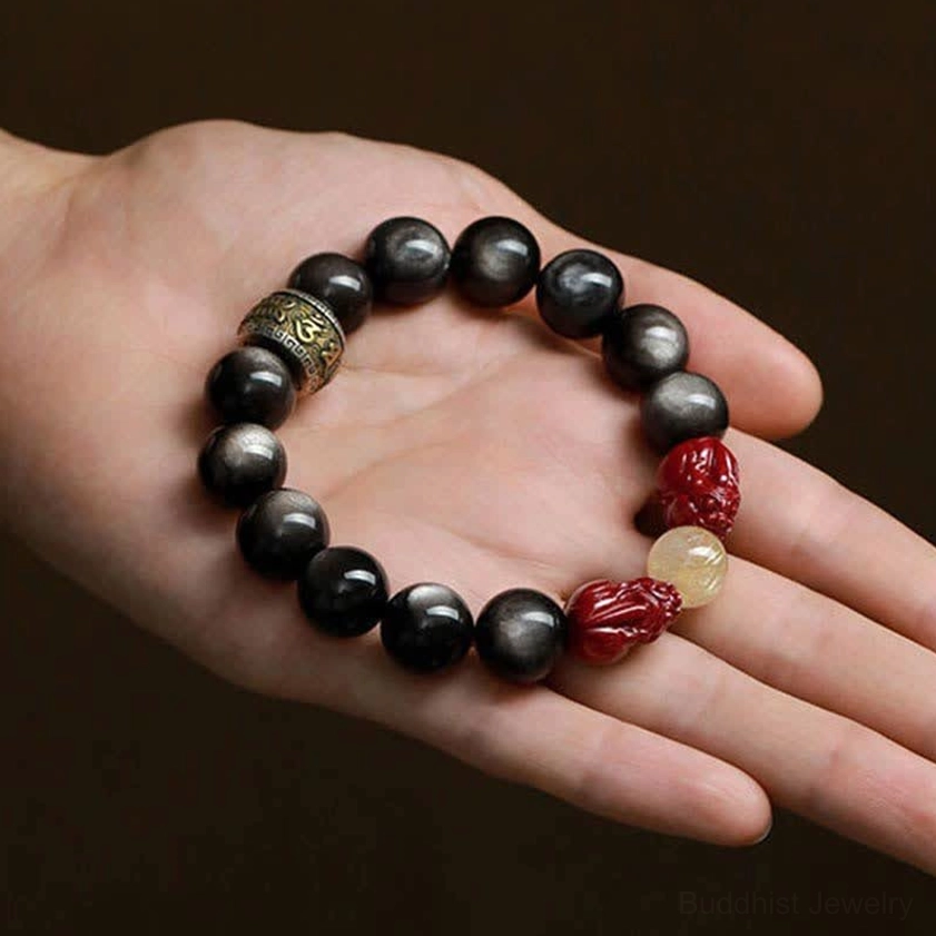 Buddhist protection bracelet with obsidian beads and pixiu on human palm display