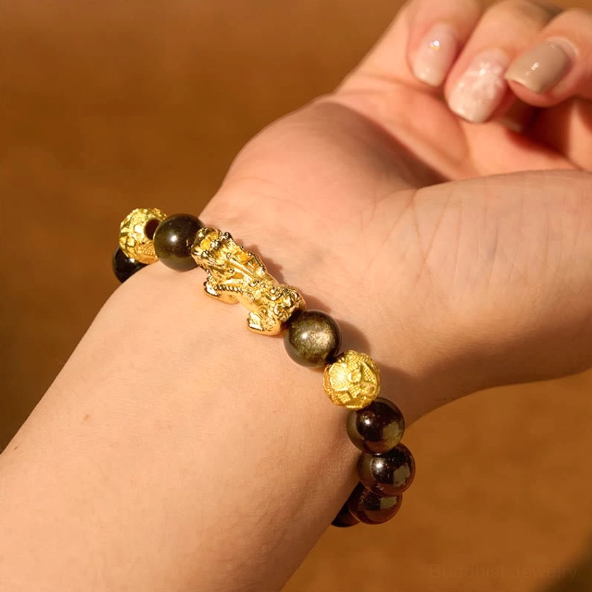 Gold sheen obsidian Pixiu bracelet on wooden background, side view showcasing the black obsidian beads with golden sheen, gold-plated accents, and detailed charm work