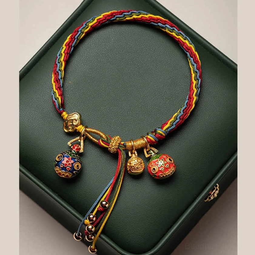 Gold Swallowing Beast protection bracelet in dark green jewelry box with multicolor braid and three charms
