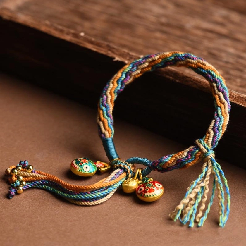 Gold swallowing beast family fortune braided string bracelet showing the sacred reincarnation knot weaving and enamel charm details
