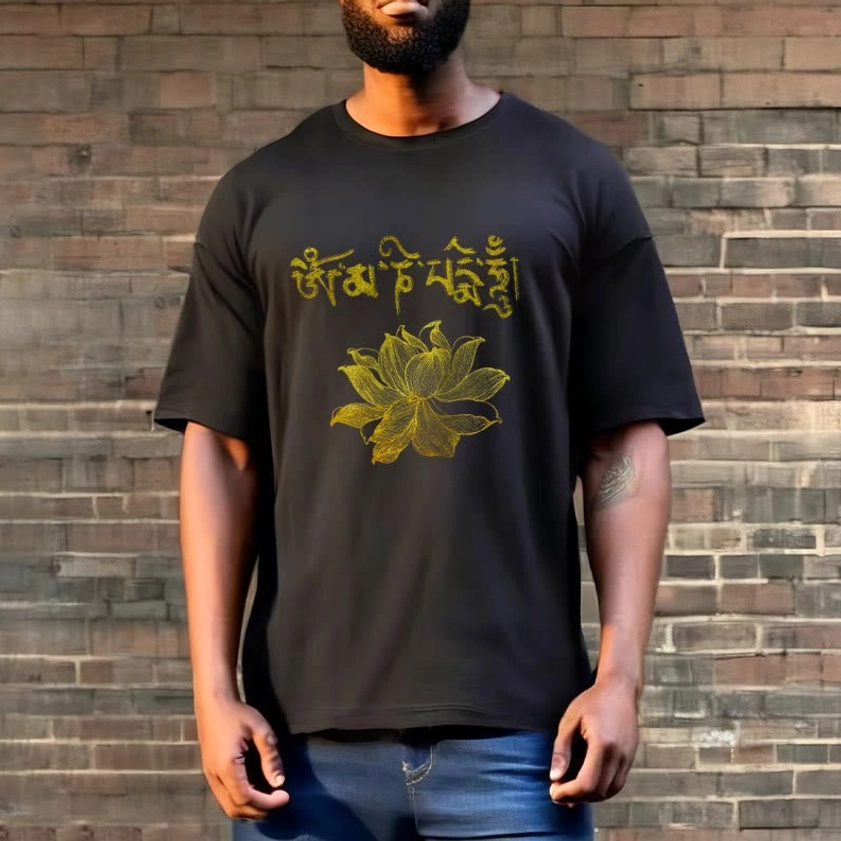 Model wearing black Buddhist graphic t-shirt with golden Sanskrit mantra and lotus design - casual spiritual fashion on brick wall background
