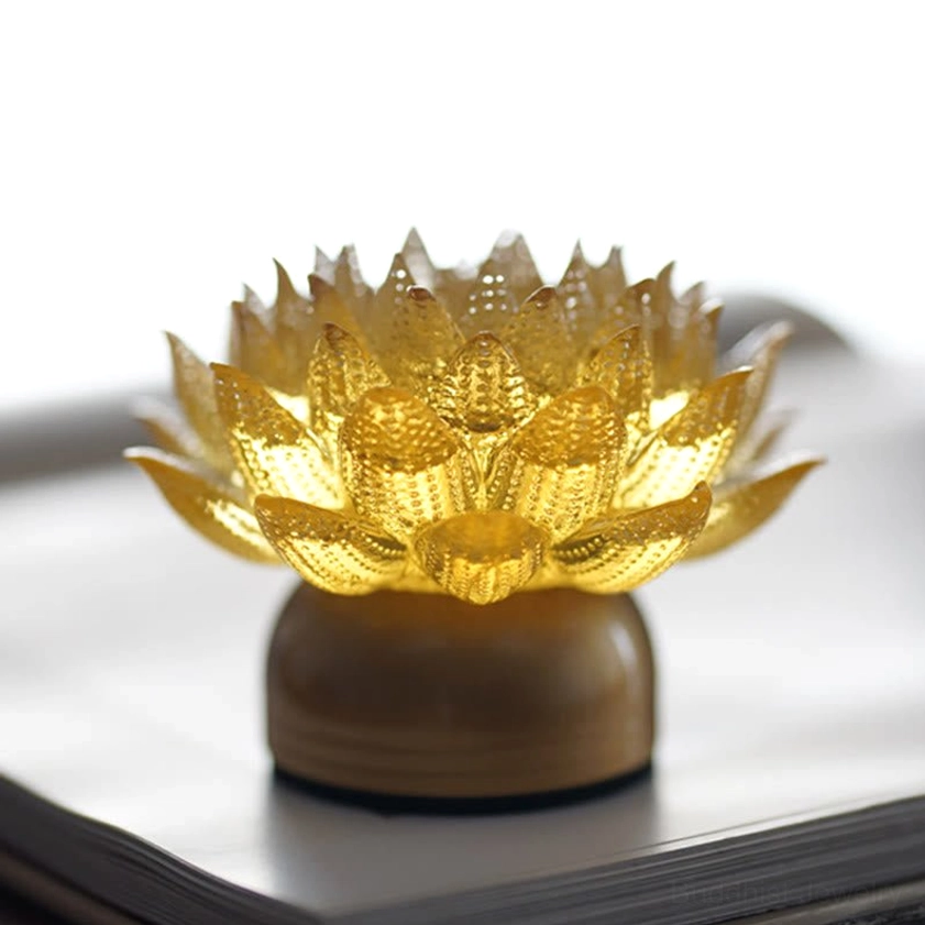 Golden lotus liuli glass sculpture with integrated lighting, warm soft glow for meditation space
