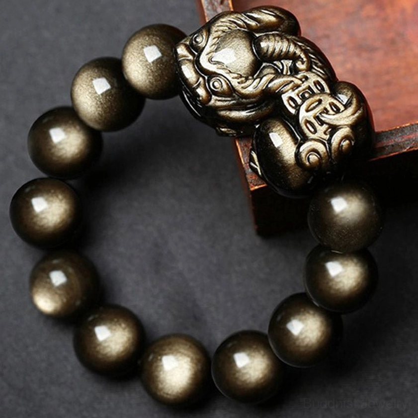 Pixiu talisman bracelet draped on wooden display block showcasing the carved metal charm detail