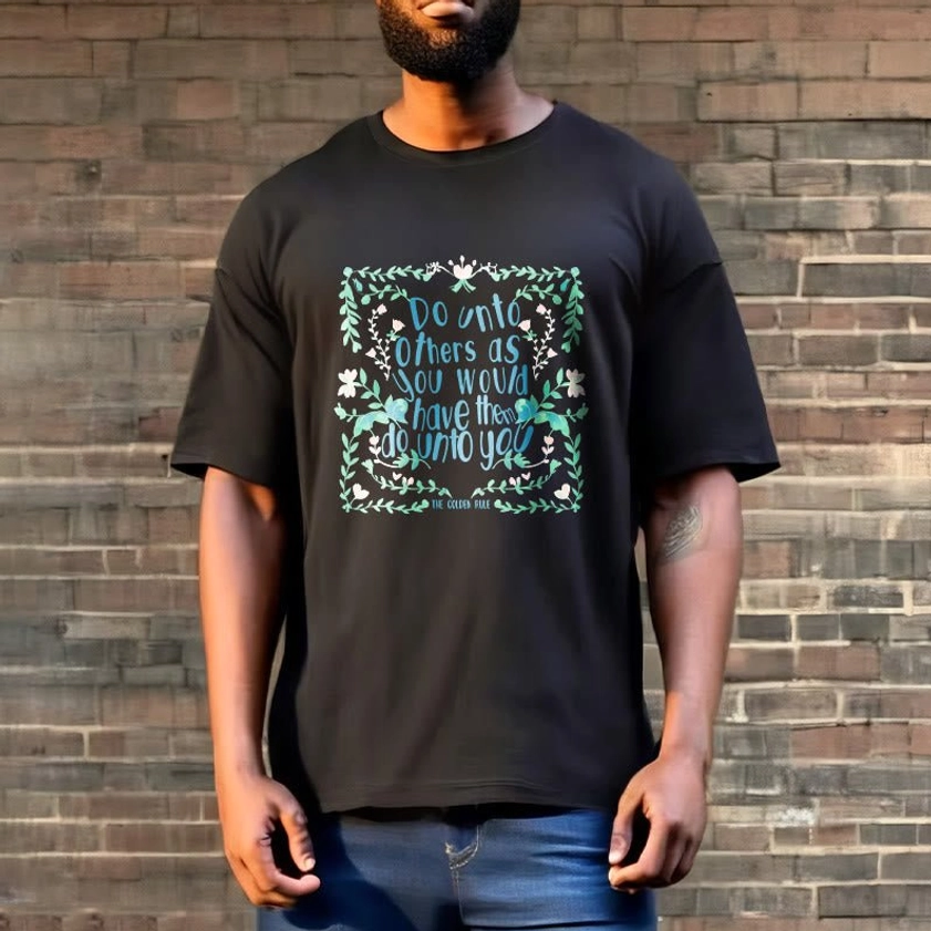 Male model wearing black Buddhist spiritual t-shirt with teal golden rule floral design brick wall backdrop