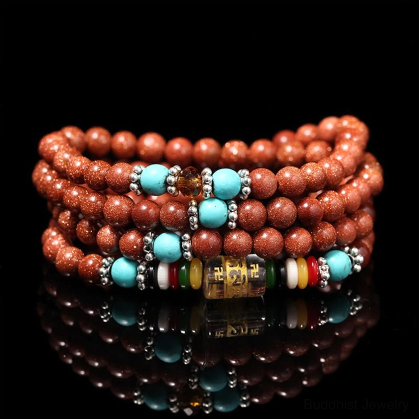 108 Goldstone Mala Bracelet with Om Mani Padme Hum mantra beads and turquoise accents, top-down view showing reddish-brown sparkly beads
