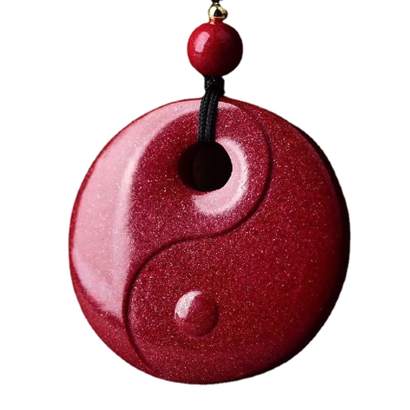 Gourd cinnabar pendant showing carved design on wine-red stone with granular texture displayed on ceramic tabletop