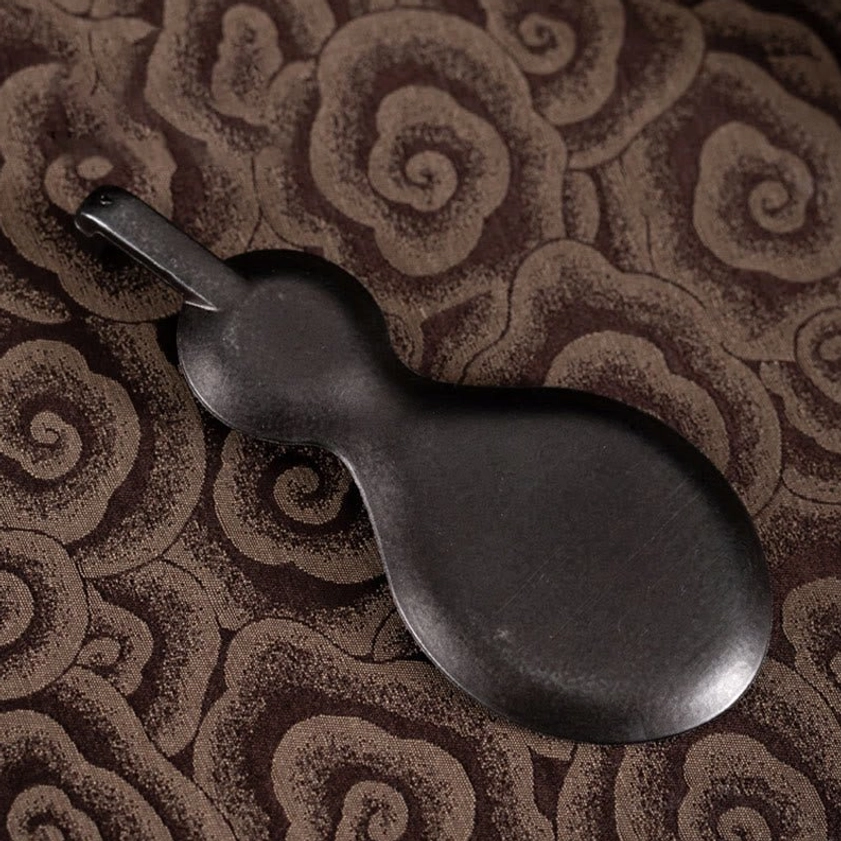 Smooth matte black side view of handcrafted gourd incense holder showing metallic finish
