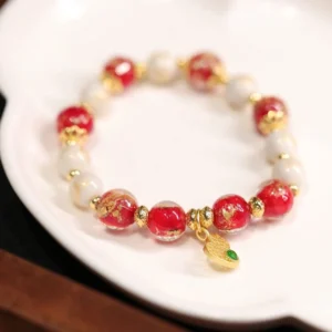 Red and white Liuli glass bead bracelet with gold gourd wealth charm pendant, featuring green gemstone accent and handmade incense ash porcelain beads for Buddhist prosperity