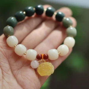 Gradient bodhi seed amber lotus bracelet for peace and enlightenment - overhead palm view showcasing gradient beads with yellow rose charm and red accents