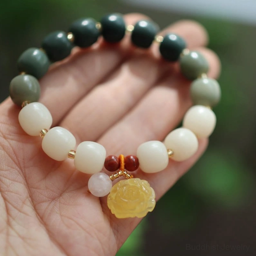 Gradient bodhi seed amber lotus bracelet for peace and enlightenment - overhead palm view showcasing gradient beads with yellow rose charm and red accents
