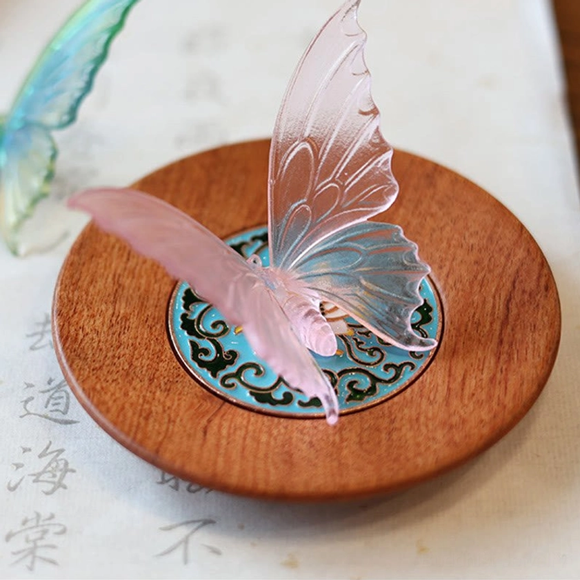 Top-down view of gradient blue-pink butterfly incense burner on calligraphy desk