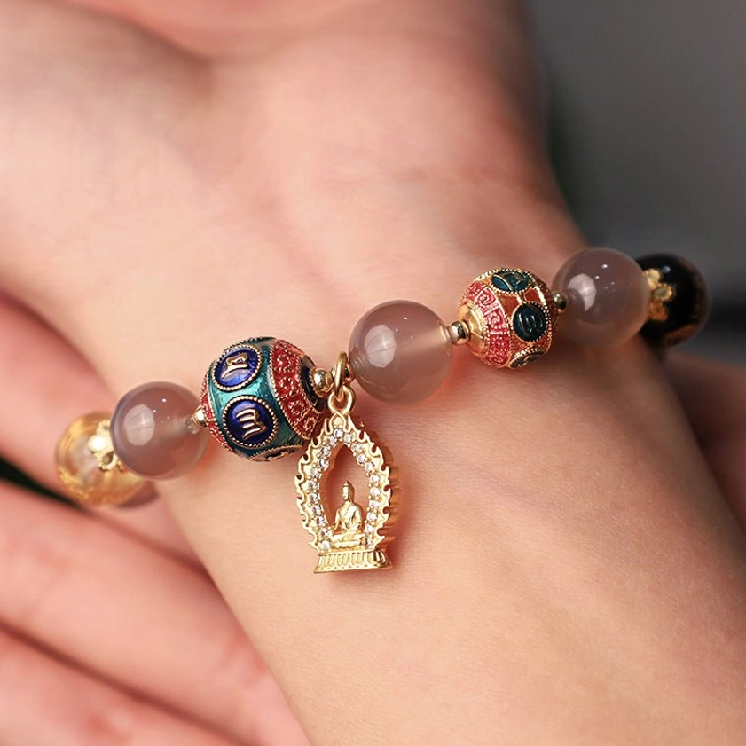 Gray agate Om Mani Padme Hum Buddha bracelet worn on wrist, showing natural stone beads and gold Buddha pendant in close-up