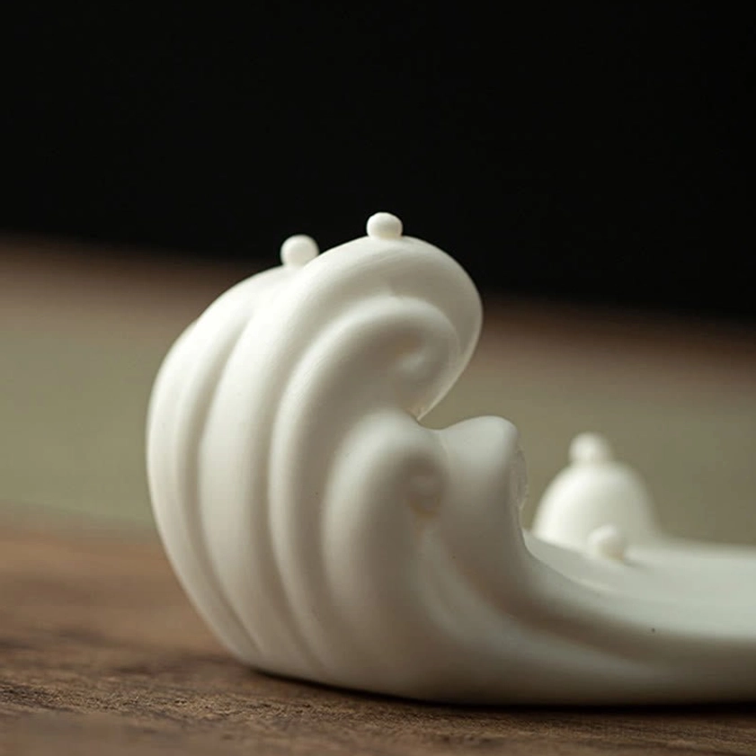 Gray handcrafted ceramic Buddhist incense holder with elegant monk figure and flowing waves