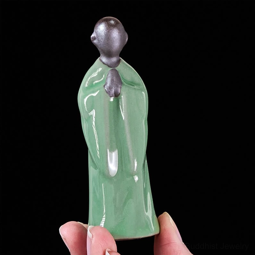 Gray ceramic monk statue meditating peaceful expression spiritual anchor point