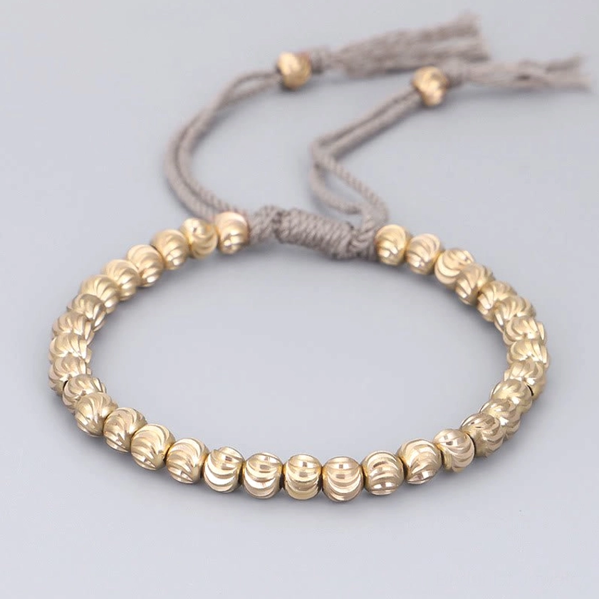 Gray adjustable copper bead bracelet for spiritual practice, flat lay on neutral background