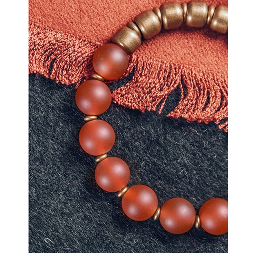 Green agate Buddhist bracelet flat lay showing natural round beads and hammered copper accents