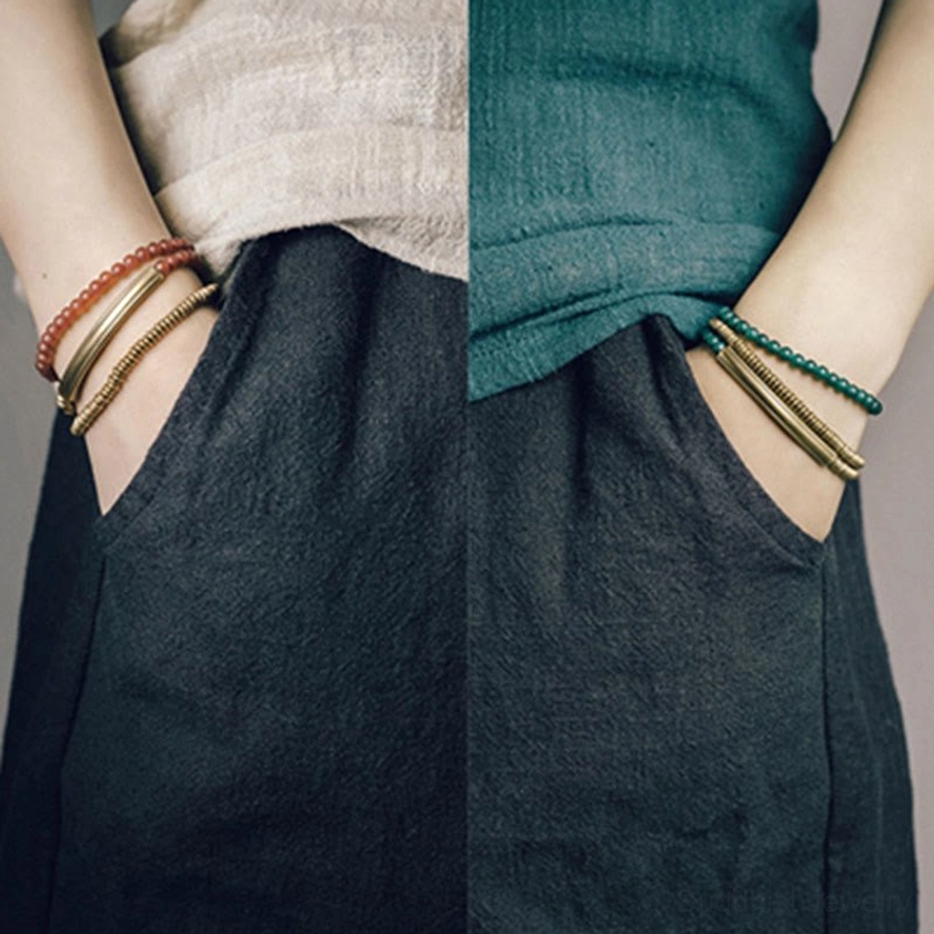 Green agate Buddhist protection bracelet worn on wrist side profile view showing slim stacked wrap design with brass metal accents and daily wear styling