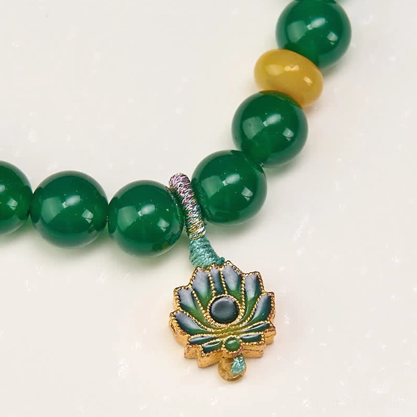 Macro close-up of green agate lotus bracelet showing smooth polished beads, yellow agate bead, wrapped knot construction, and detailed enamel lotus pendant