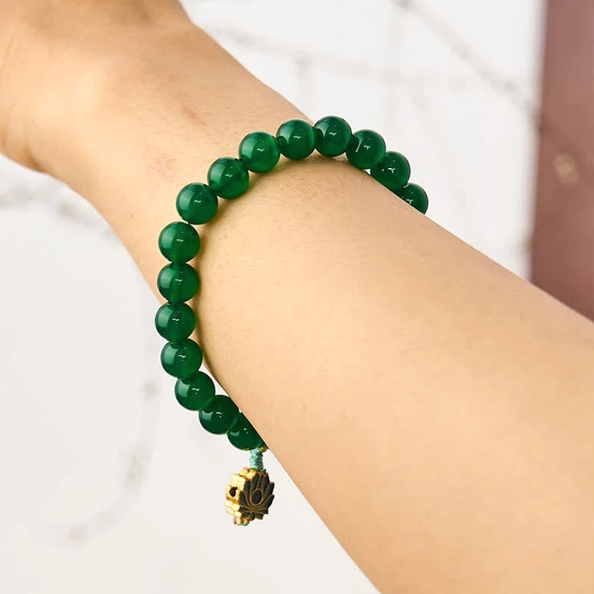Green agate lotus bracelet worn on wrist side view showing how the bracelet looks when worn, with gold lotus charm visible