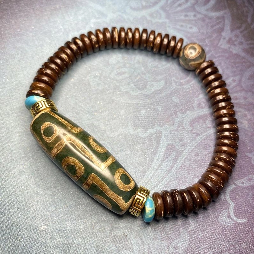 green agate nine-eye dzi bead bracelet featuring elongated eye patterns with turquoise and silver hardware details