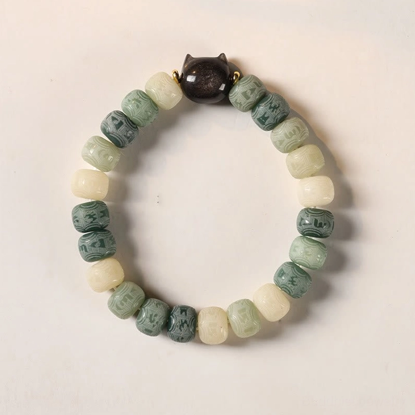 Green bodhi seed Om Mani Padme Hum bracelet with cat head charm flat lay product photography