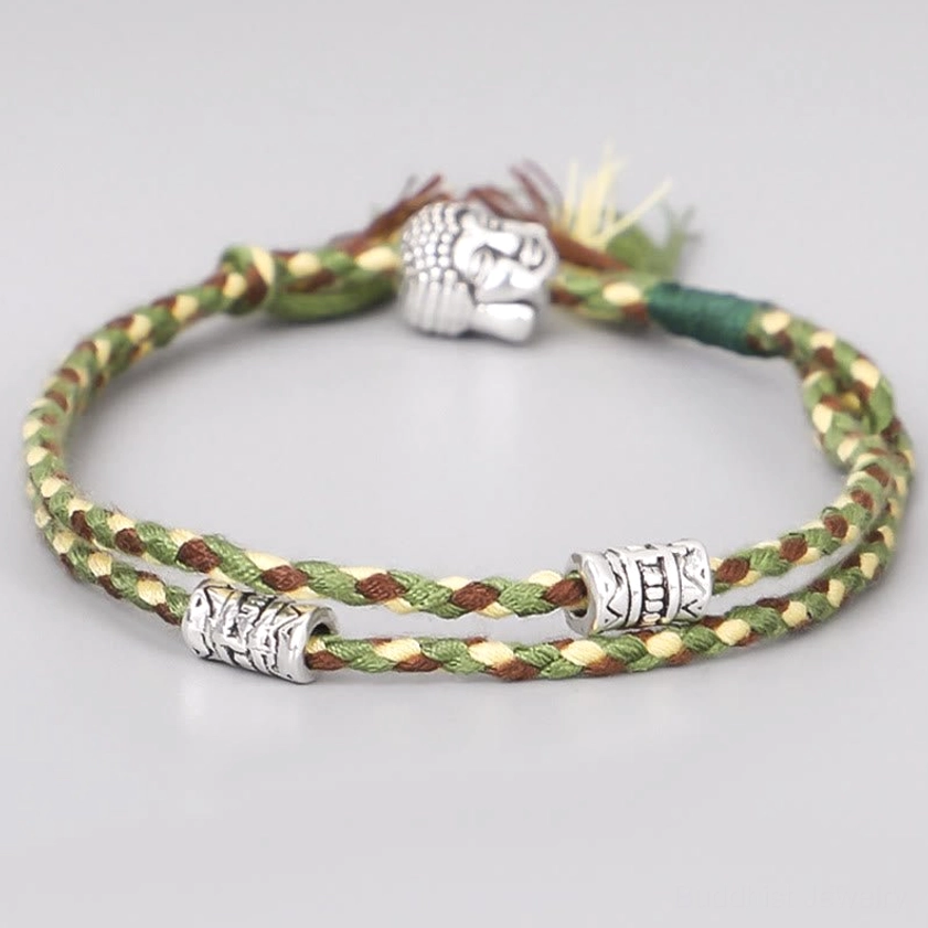 Green braided Buddha head string bracelet with silver alloy charm, front view on white background