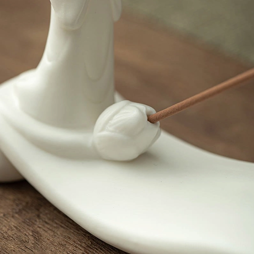 Green ceramic Buddhist incense burner featuring tranquil monk sculpture and mountain wave motif