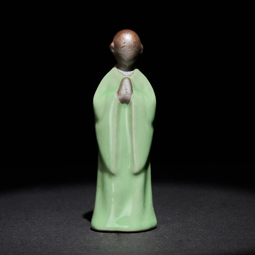 Green contemplation monk ceramic statue meditating deep spiritual focus